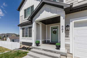 Property entrance with board and batten siding, a residential view, a porch, and fence