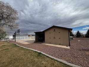 View of outdoor structure with an outbuilding and fence