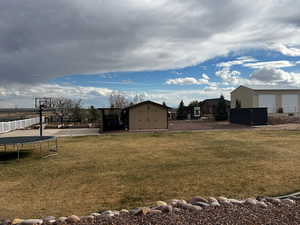 View of yard with an outbuilding and fence