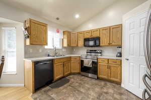 Kitchen with light countertops, pendant lighting, a sink, and black appliances