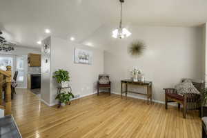 Living area with recessed lighting, light wood finished floors, visible vents, baseboards, and a notable chandelier