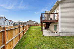 View of yard featuring a fenced backyard, a wooden deck, stairway, and a patio