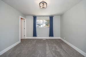Carpeted spare room with baseboards