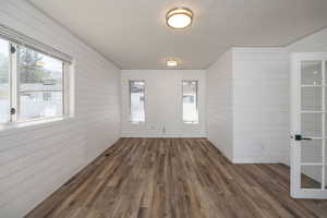 Interior space featuring wooden walls and dark wood-style floors