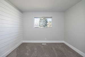 Empty room featuring carpet flooring and baseboards