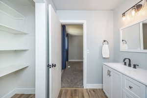 Bathroom with wood finished floors, vanity, and baseboards