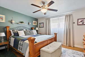 Bedroom featuring baseboards, wood finished floors, and ceiling fan