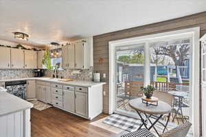 Kitchen featuring dishwasher, decorative backsplash, and plenty of natural light