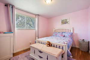 Bedroom with baseboards and wood finished floors