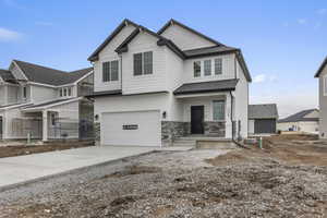 Craftsman house featuring a shingled roof, an attached garage, driveway, and stone siding