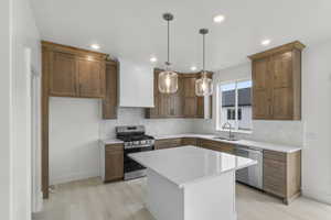 Kitchen with stainless steel appliances, a sink, recessed lighting, and tasteful backsplash