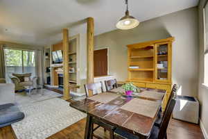 Dining space with built in features, baseboards, wood finished floors, and a glass covered fireplace