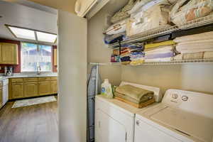 Laundry room featuring visible vents, a sink, laundry area, dark wood-type flooring, and washing machine and dryer