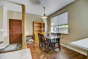 Dining area with baseboards and dark wood-style floors