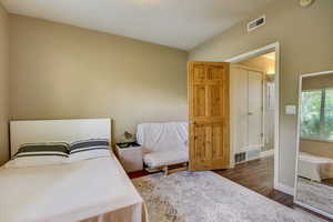 Bedroom with visible vents, baseboards, and wood finished floors