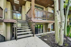 View of exterior entry with stucco siding and stone siding
