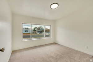 Empty room with baseboards and carpet