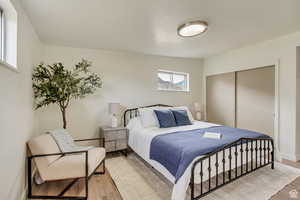Bedroom featuring baseboards, light wood-style floors, and a closet
