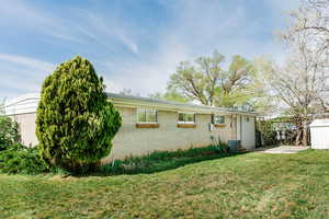 View of front of property featuring central AC unit and a front yard