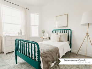 Bedroom with baseboards and light carpet