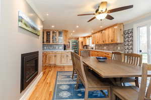 Dining space with recessed lighting, a glass covered fireplace, crown molding, and a ceiling fan