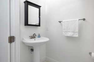 Bathroom featuring baseboards and a sink