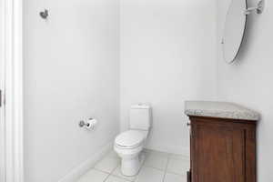 Bathroom featuring baseboards, tile patterned flooring, and toilet