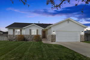Ranch-style home with stone siding, driveway, and an attached garage