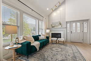 Living area featuring plenty of natural light, a tile fireplace, high vaulted ceiling