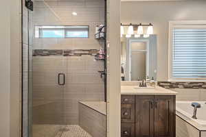 Full bathroom featuring a shower stall, vanity, and a garden tub