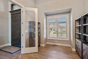 Entryway featuring wood finished floors, baseboards, and visible vents