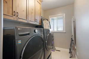 Laundry room with baseboards, tile patterned flooring, visible vents, independent washer and dryer, and cabinet space
