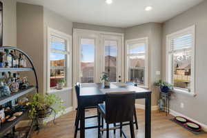 Dining area featuring baseboards, recessed lighting, wood finished floors, and a healthy amount of sunlight