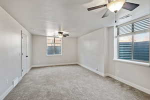 Unfurnished room featuring ceiling fan, baseboards, carpet, and visible vents
