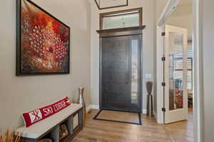Foyer with baseboards and wood finished floors
