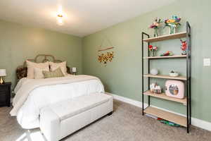 Carpeted bedroom with a textured ceiling and baseboards