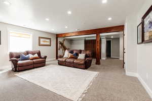 Living room with light carpet, baseboards, and recessed lighting