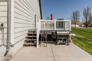View of patio with grilling area and a deck