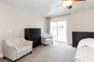 Bedroom with ceiling fan, baseboards, access to outside, and light colored carpet