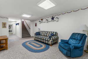 Tiled living area featuring stairway and baseboards