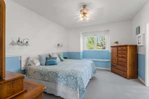 Bedroom with ceiling fan, light carpet, and baseboards