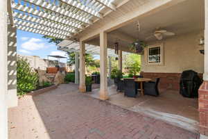 View of patio / terrace featuring a pergola, fence, ceiling fan, grilling area, and outdoor dining space