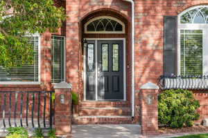 Doorway to property featuring brick siding