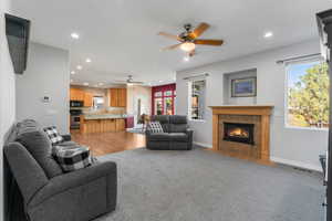 Living area with a ceiling fan, visible vents, recessed lighting, and a fireplace