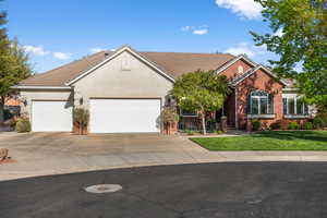View of front of house featuring a tile roof, concrete driveway, an attached garage, a front yard, and stucco siding