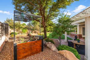 View of yard with a pergola and a garden