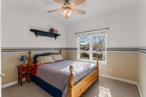 Carpeted bedroom with baseboards and a ceiling fan