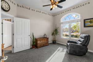 Sitting room with ceiling fan, a wealth of natural light, baseboards, and carpet