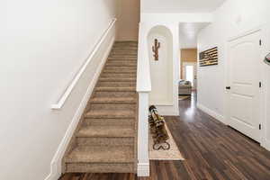 Stairs with wood finished floors and baseboards
