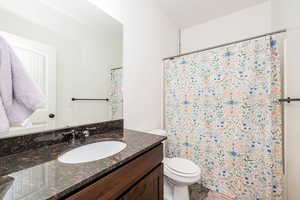Full bath featuring a shower with curtain, vanity, and toilet